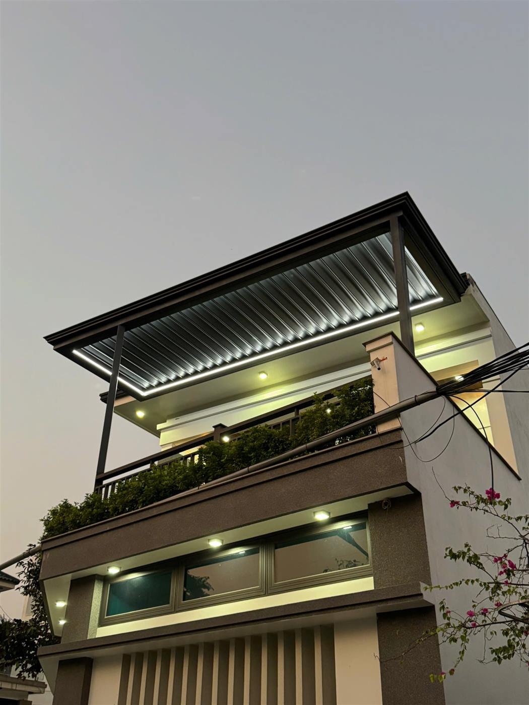 Mái nhôm xếp tự động sân thượng có đèn LED viền lúc hoàng hôn